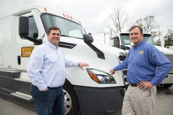 Wright Transportation owners standing by a truck
